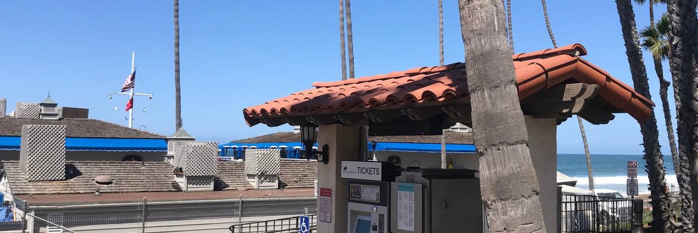 The ticket machine at San Clemente Pier station, with the ocean behind